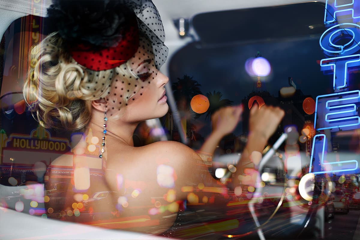 Femme en voiture de nuit à Hollywood avec un voile et un chapeau